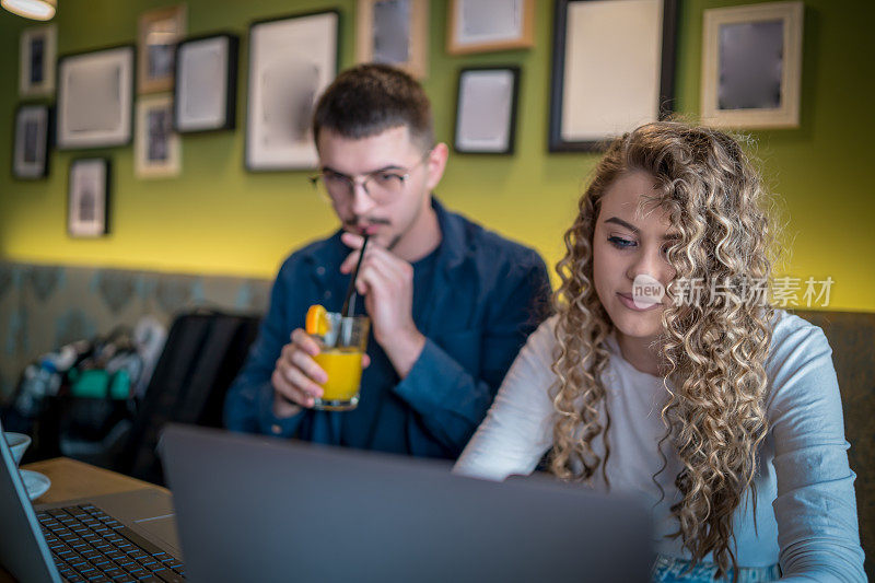 Business people working together at a café using their laptops